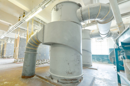 Industrial ventilation system in a manufacturing facility highlighting large ductwork and machinery