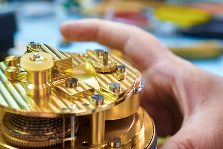 Intricate craftsmanship shines as hands delicately repair an exquisite chronometer in a workshop filled with tools and materialsの写真素材
