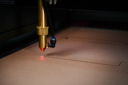 Precision laser cutting of cardboard sheets in a modern box manufacturing facility showcasing innovative technology at workの写真素材