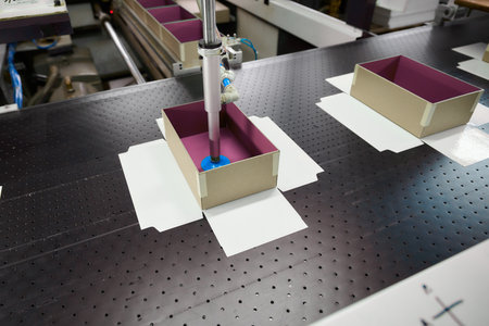 Innovative robot assembly in an automated box manufacturing plant showcasing precision gluing techniques and industrial progressの写真素材