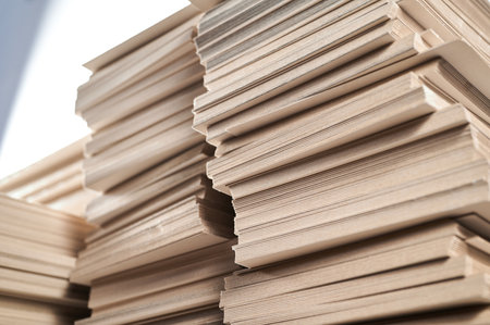 Stacks of thick paperboard awaiting transformation into durable cardboard boxes at a manufacturing facilityの写真素材