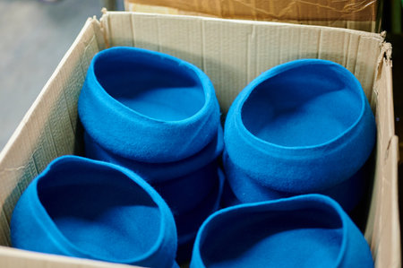 Crafting vibrant blue berets in a bustling felt factory during the afternoon hoursの写真素材