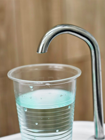 Water flows into a clear cup during a dental check-up at a modern clinic with a calm atmosphere