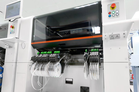 High-precision SMT pick-and-place machine with tape feeders in a modern electronics assembly...