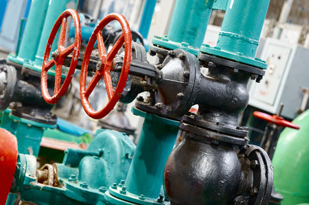 Machinery with red valve handles and metal pipes shows industrial design in a manufacturing facility