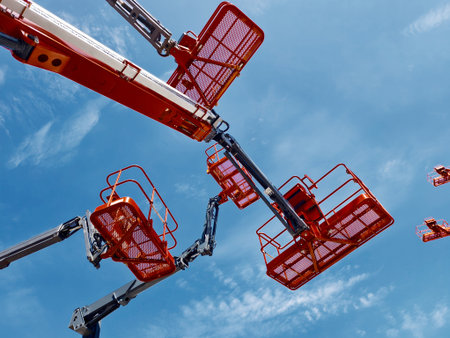High reach equipment with multiple booms against a clear blue sky during daylight hours
