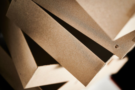 Cardboard box blanks stacked in a cardboard box manufacturing facility ready for assembly and packaging in the production processの写真素材