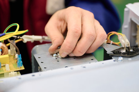 Assembly process of microwave oven electrical components on conveyor system in manufacturing facilityの写真素材