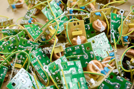 Circuit boards scattered across a table showcase intricate designs and electrical components in a workshop settingの写真素材