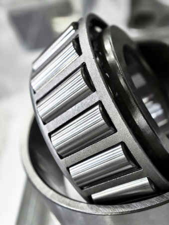 Close-up view of precision steel roller bearings in a manufacturing facility during the assembly...