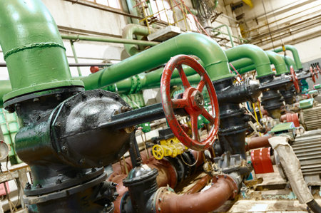 Industrial water pipes and valves in a manufacturing facility active during daylight hours