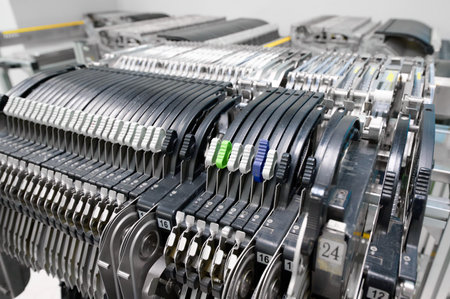 Detailed view of tape feeders in an SMT pick-and-place machine during assembly in a manufacturing...