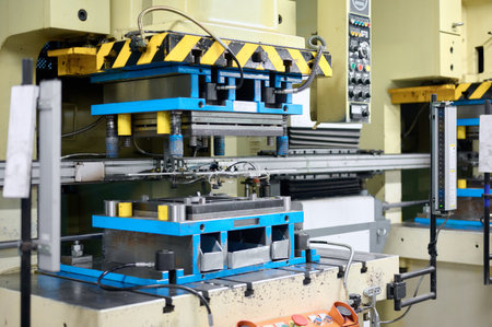 Cold metal stamping and pressing production line with precision machinery in operation at a...