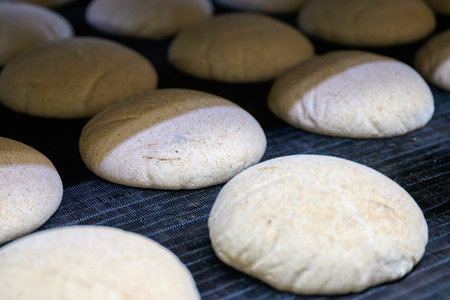 Farmhouse bran dough processes inside a bakery oven inlet at early morning hoursの写真素材