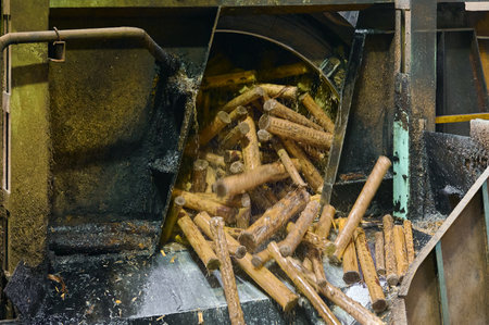 Drum debarker in action with logs being processed for wood industry efficiencyの写真素材