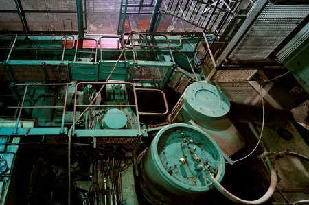Complex machinery and piping in a spacious industrial setting during late evening hours