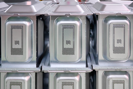 Rows of microwave oven casings stacked in a warehouse ready for assembly and distribution in an appliance storeの写真素材