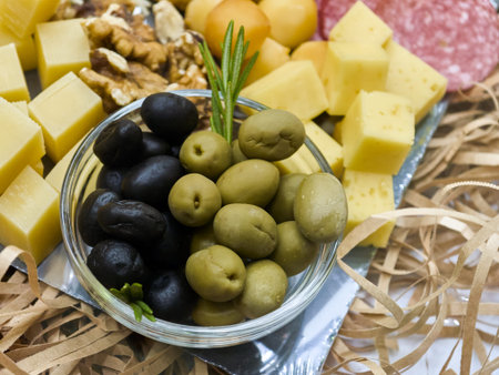 Delightful cheese and olive platter adorned with nuts and salami for an elegant gathering