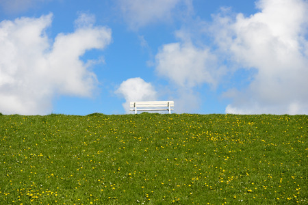 empty bench on dike near cuxhavenの写真素材