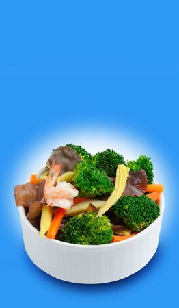 fried mix vegetable and shrimp in bowl on blue backgroundの写真素材