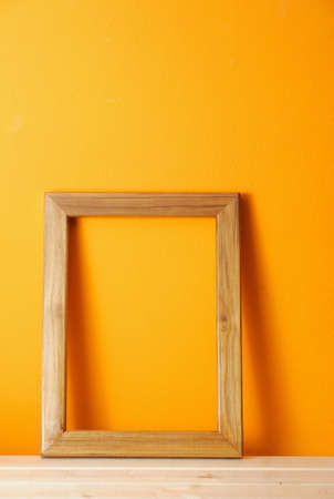 wooden picture frame on orange wallの写真素材