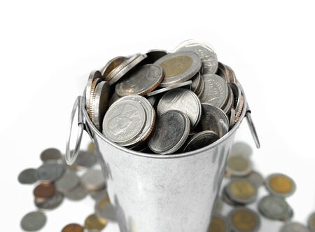 metal bucket full with coin isolate on whiteの写真素材