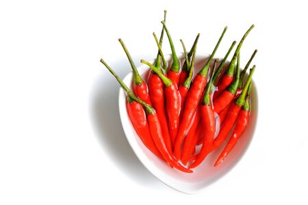 red hot chili peppers in bowl isolate on white backgroundの写真素材