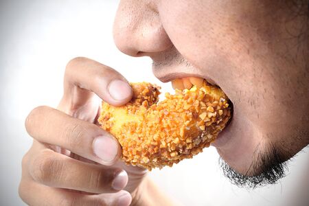 hungry man eating a doughnutの写真素材