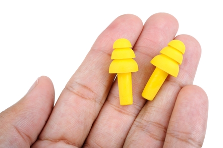 yellow ear plugs isolated in hand