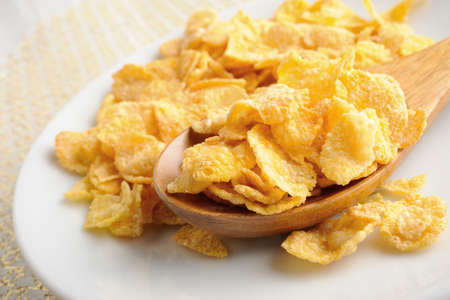 closeup corn flake in wooden spoon