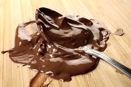chocolate melted on wooden chopping blockの写真素材