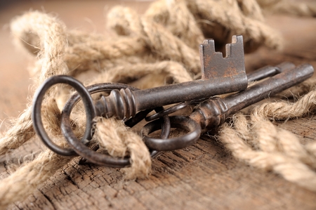 bunch of vintage keys with rope on old wooden plankの写真素材