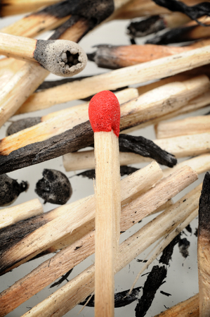 closeup red wooden match on burned matchesの写真素材
