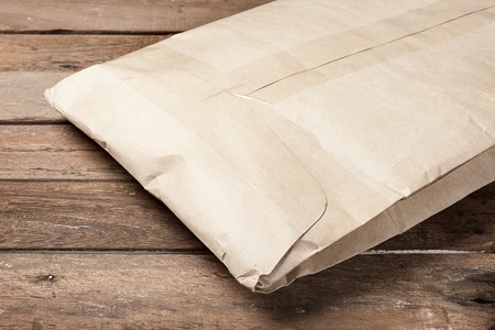 closeup brown envelope on wooden plankの写真素材