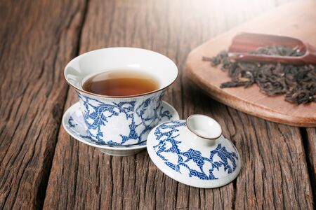 tea cup with tea leaf isolated on wooden plankの写真素材