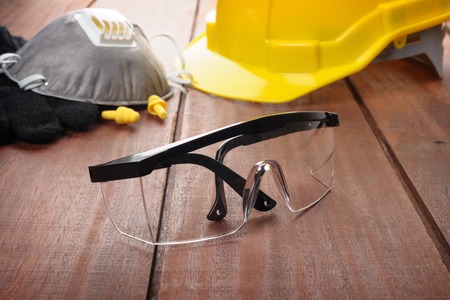 safety glasses on wooden plank