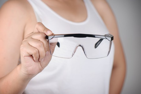 closeup clear safety glasses in handの写真素材