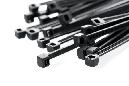 heap of black cable ties on white background