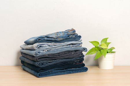 stack of denim jeans isolate on wooden deskの写真素材