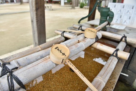 OSAKA, JAPAN - NOVEMBRER 06, 2014 : Japanese purification fountain in Shitennoji temple. Shinto believers rinse their mouths and clean their hands before worshiping at Shitennoji temple.のeditorial素材