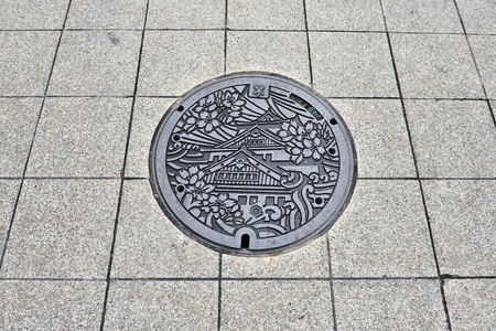 OSAKA, JAPAN - NOVEMBER 06, 2014: Art on the surface of sewer cover on the walk way.のeditorial素材