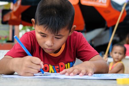 CHONBURI, THAILAND - AUGUST 23, 2014: Unidentified boy coloring at Ban Kru Boonchoo. Ban Kru Boonchoo is the home for abandoned Down Syndrome kids.のeditorial素材