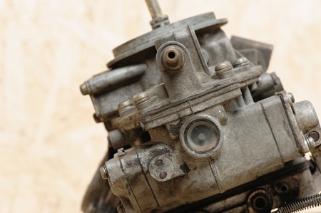 closeup old and dirty carburetor on wooden deskの写真素材