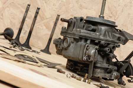 closeup old and dirty carburetor on wooden deskの写真素材
