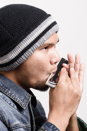 young adult playing the harmonica