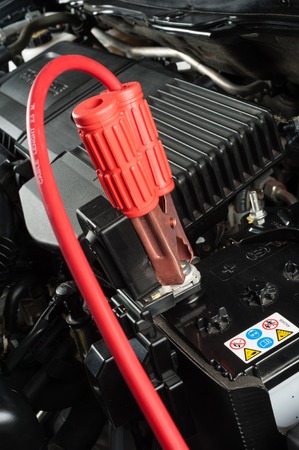 car battery with jumper cable in engine room