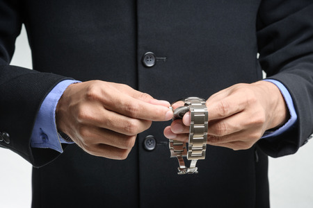 businessman adjusting the time on his watchの写真素材
