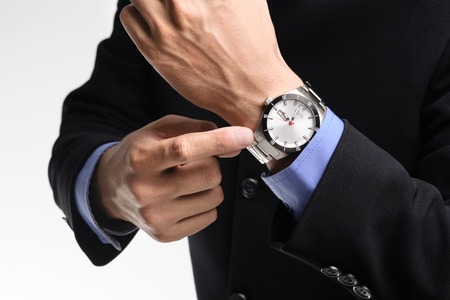 businessman pointing angrily to his watchの写真素材