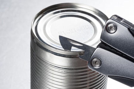 opening the tin with tin opener (can opener)