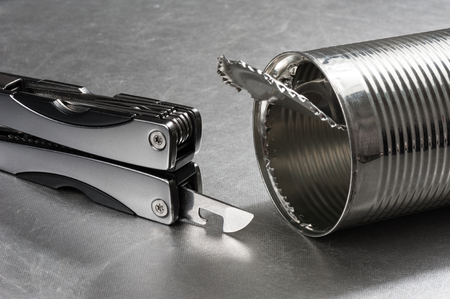 opening the tin with tin opener (can opener)の写真素材